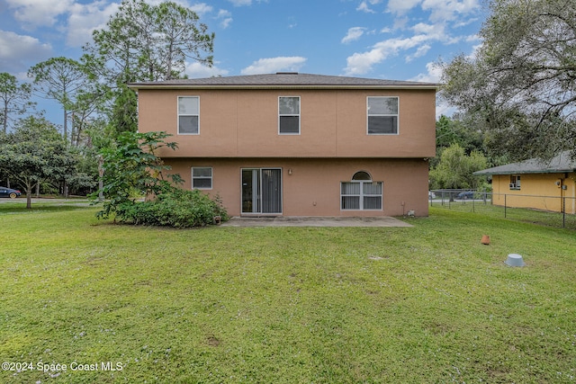 back of property featuring a lawn and a patio