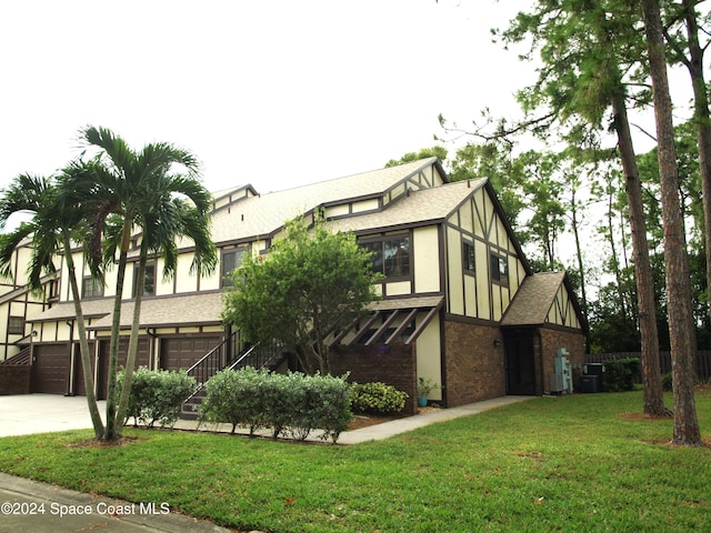 view of front facade featuring central air condition unit, a garage, and a front yard