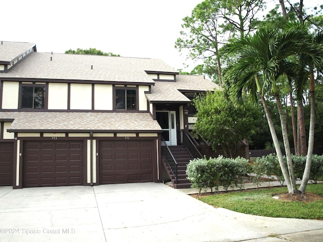 753 Greenwood Manor Cir Unit 15B, West Melbourne, FL 32904 - view of front of house featuring driveway, a shingled roof, an attached garage, and stucco siding