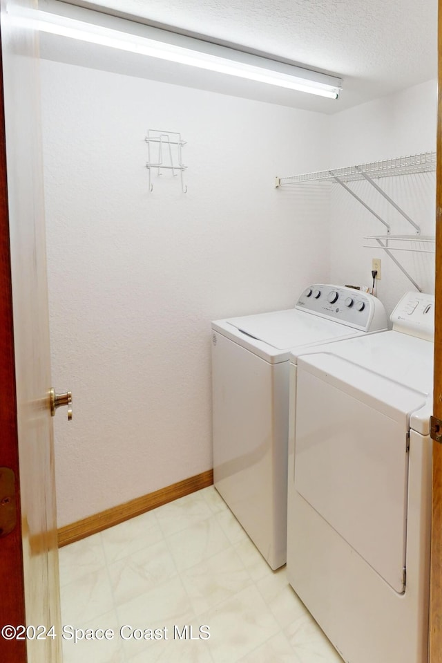 753 Greenwood Manor Cir Unit 15B, West Melbourne, FL 32904 - washroom featuring washing machine and dryer, baseboards, and light flooring