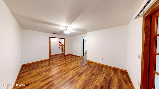 753 Greenwood Manor Cir Unit 15B, West Melbourne, FL 32904 - empty room featuring light wood-type flooring, baseboards, a ceiling fan, and stairway