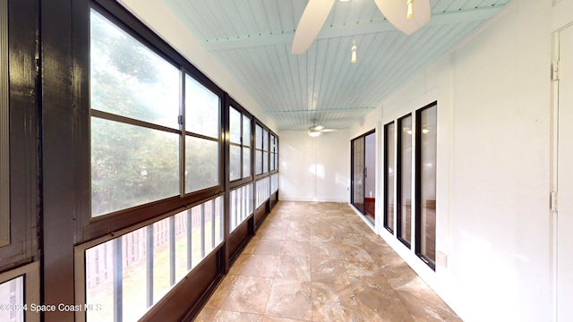 unfurnished sunroom featuring wooden ceiling, ceiling fan, and beam ceiling