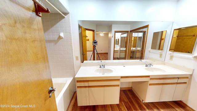 bathroom featuring tiled shower / bath combo, vanity, hardwood / wood-style flooring, and ceiling fan