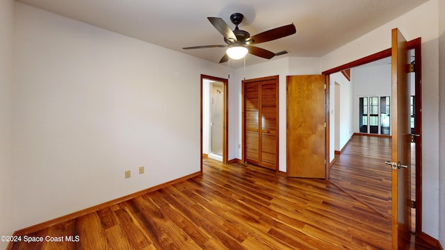 753 Greenwood Manor Cir Unit 15B, West Melbourne, FL 32904 - unfurnished bedroom with wood finished floors, baseboards, a closet, and a ceiling fan