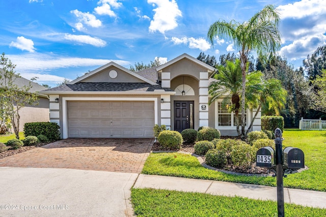 view of front of home with a front yard and a garage