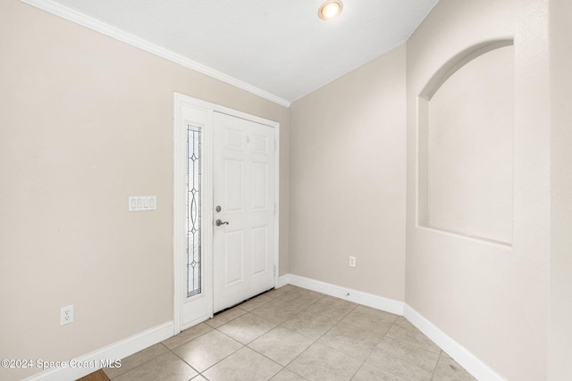 foyer entrance featuring crown molding, lofted ceiling, and light tile patterned floors