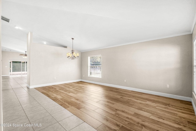 empty room with lofted ceiling, light hardwood / wood-style flooring, ceiling fan with notable chandelier, and ornamental molding