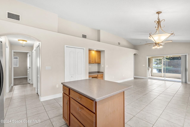 kitchen with a kitchen island, vaulted ceiling, hanging light fixtures, and light tile patterned floors