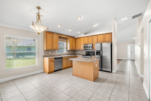 kitchen featuring lofted ceiling, a center island, stainless steel appliances, and plenty of natural light