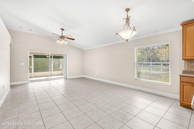 interior space featuring ornamental molding, ceiling fan, light tile patterned floors, and vaulted ceiling