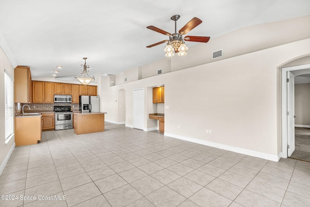 kitchen with pendant lighting, stainless steel appliances, sink, and light tile patterned flooring