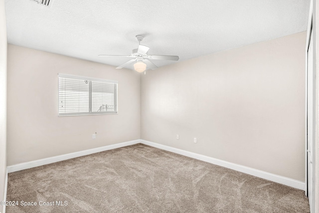 carpeted spare room with ceiling fan and a textured ceiling