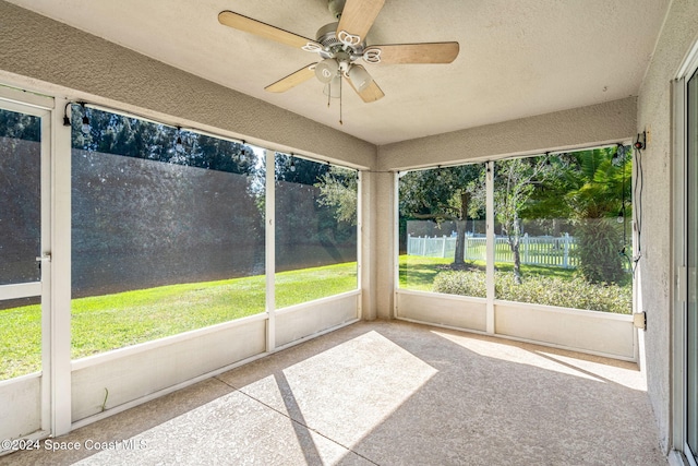 unfurnished sunroom with ceiling fan