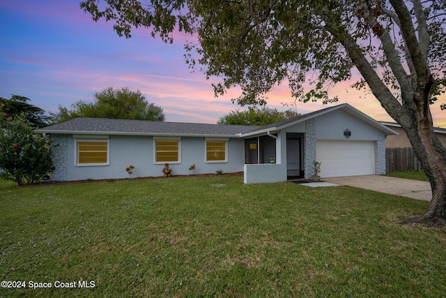 ranch-style home featuring a yard and a garage