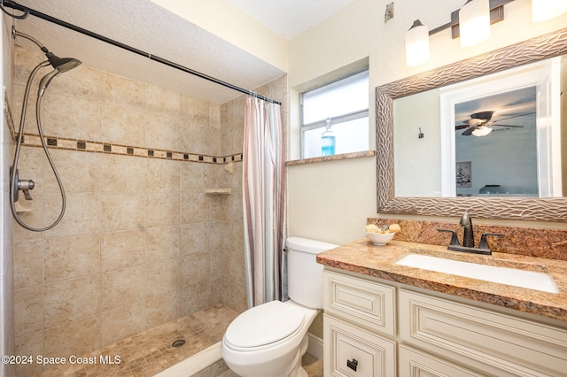 bathroom with vanity, ceiling fan, toilet, a textured ceiling, and walk in shower