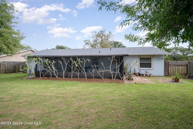 back of property featuring a sunroom and a yard