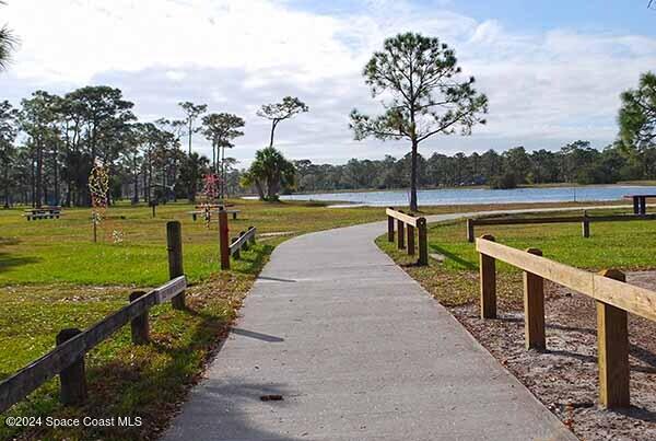 surrounding community with a lawn and a water view