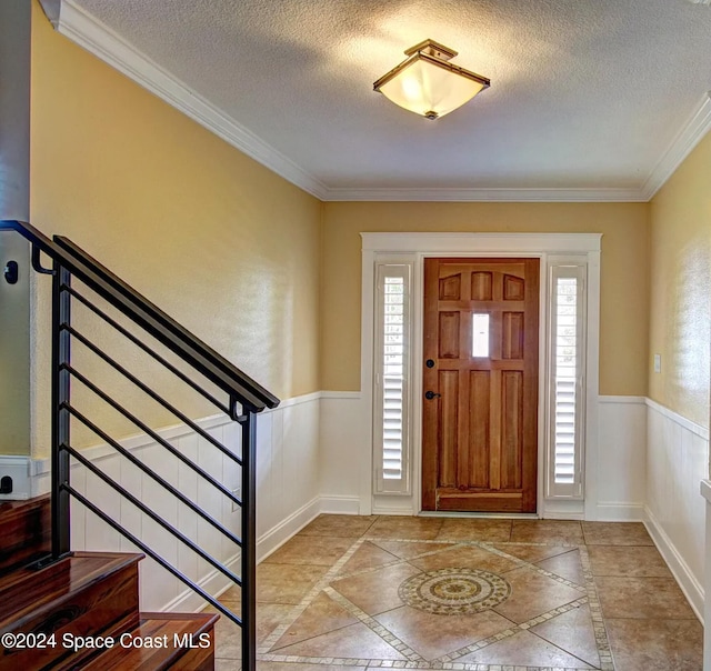 entryway featuring a textured ceiling and crown molding