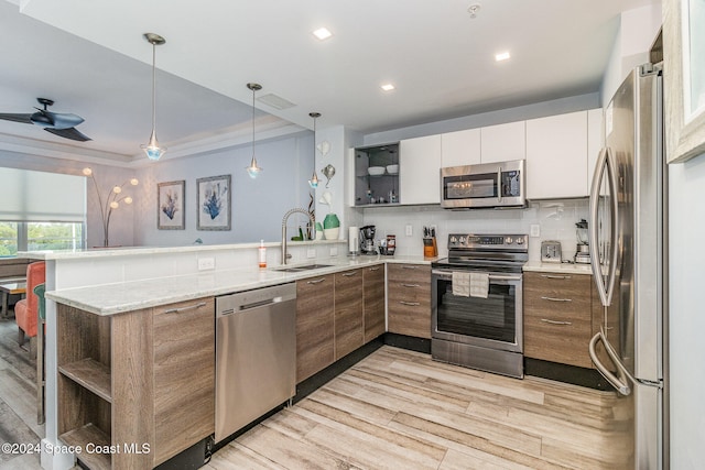 kitchen with sink, light wood-type flooring, kitchen peninsula, stainless steel appliances, and white cabinets