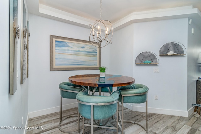 dining space featuring light hardwood / wood-style floors and an inviting chandelier