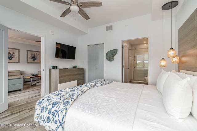 bedroom featuring connected bathroom, ceiling fan, and light wood-type flooring