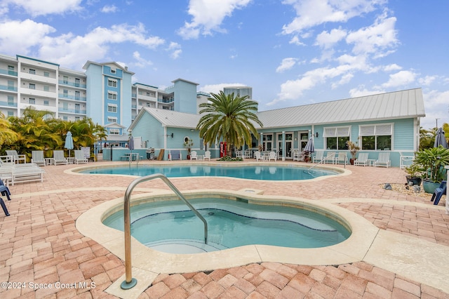 view of pool featuring a hot tub and a patio area