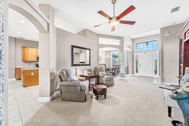 living room featuring ceiling fan with notable chandelier and light carpet