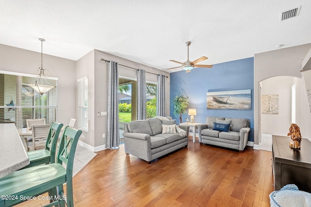 living room featuring a textured ceiling, hardwood / wood-style flooring, and ceiling fan