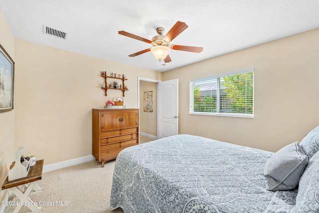 carpeted bedroom featuring a textured ceiling and ceiling fan