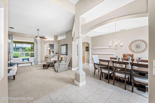 living room featuring a textured ceiling, ceiling fan with notable chandelier, light carpet, and decorative columns