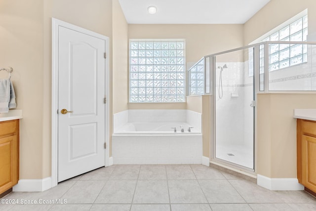 bathroom featuring tile patterned flooring, shower with separate bathtub, and vanity