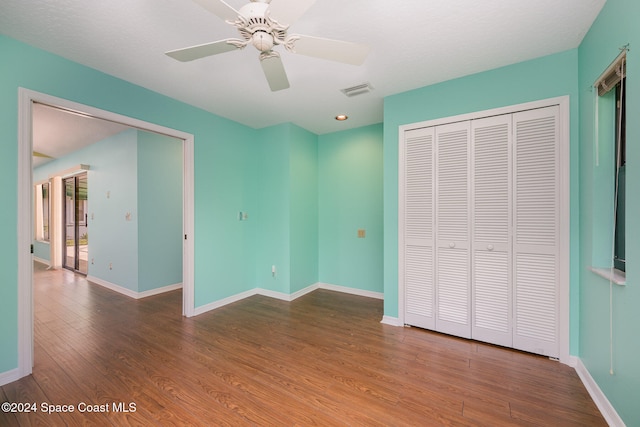 unfurnished bedroom with ceiling fan, hardwood / wood-style floors, and a closet