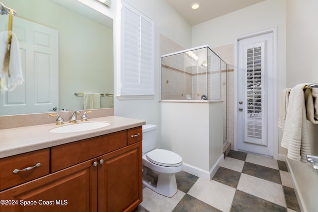 bathroom featuring vanity, a shower with shower door, and toilet