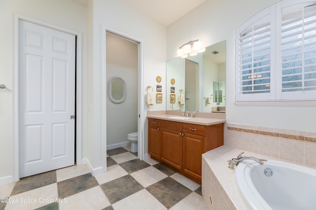 bathroom with a relaxing tiled tub, toilet, and vanity