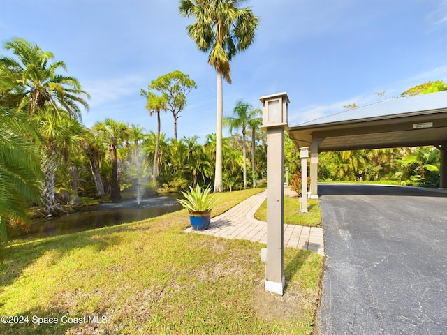 view of property's community featuring a lawn and a water view