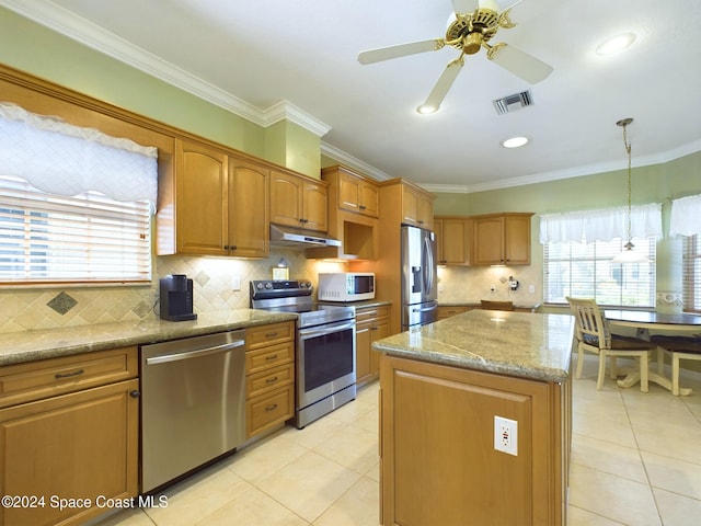 kitchen featuring appliances with stainless steel finishes, crown molding, decorative light fixtures, and a kitchen island