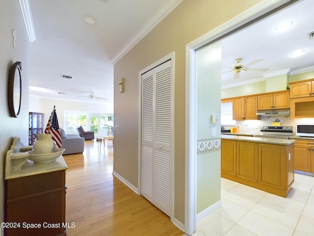 hallway featuring crown molding and light hardwood / wood-style flooring