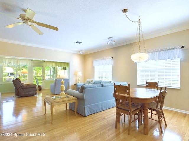 dining area featuring light hardwood / wood-style floors, crown molding, and ceiling fan