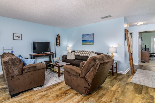 living room with hardwood / wood-style floors and a textured ceiling