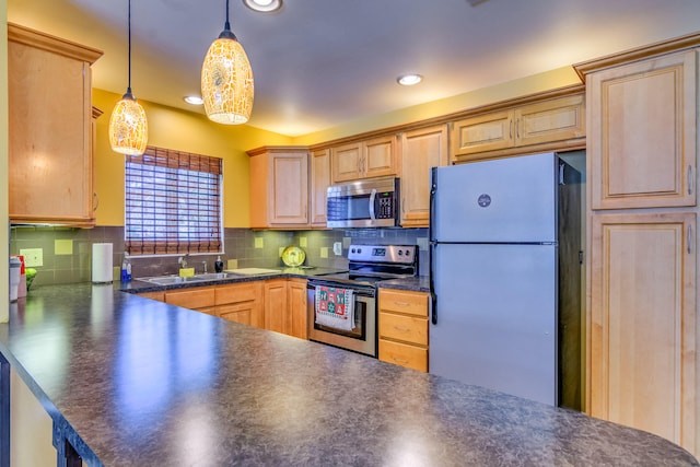 kitchen featuring tasteful backsplash, appliances with stainless steel finishes, pendant lighting, sink, and kitchen peninsula