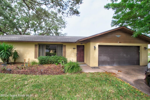 ranch-style home featuring a garage and a front lawn