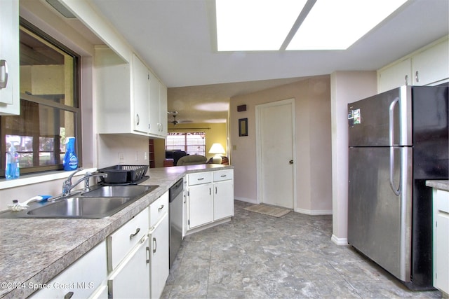 kitchen with stainless steel appliances, white cabinetry, and sink