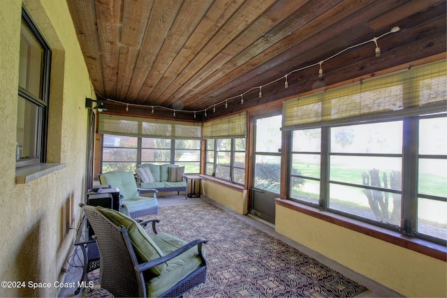 unfurnished sunroom with track lighting and wooden ceiling