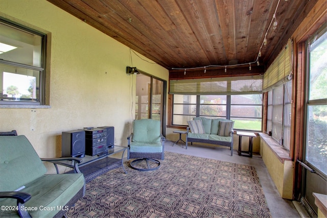 unfurnished sunroom featuring track lighting, a healthy amount of sunlight, and wooden ceiling