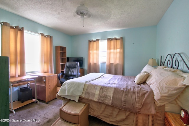 bedroom featuring ceiling fan, a textured ceiling, and carpet flooring