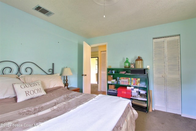 bedroom with carpet floors, a textured ceiling, and a closet