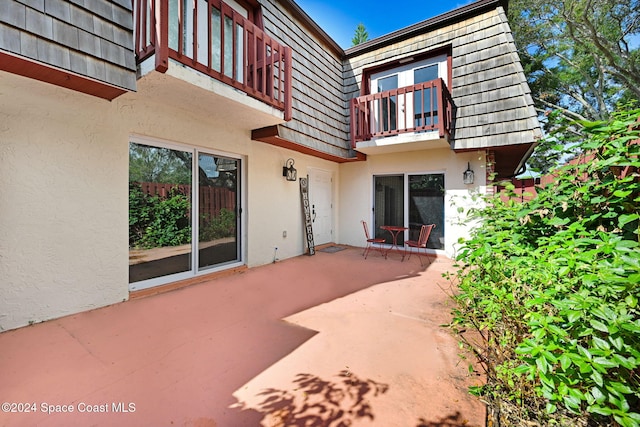 rear view of house featuring a patio area and a balcony