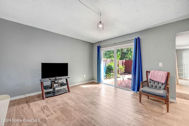 sitting room with a textured ceiling and light wood-type flooring