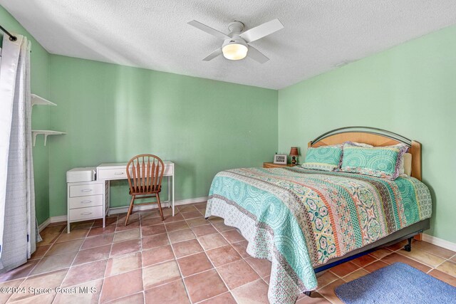 bedroom featuring a textured ceiling, tile patterned floors, and ceiling fan