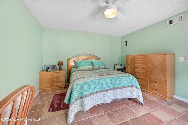 bedroom featuring a textured ceiling, tile patterned floors, and ceiling fan